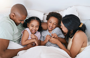 Image showing Happy family, relax and playing in bed above with smile in free time, weekend or fun holiday morning at home. Mother, father and children relaxing and laughing together for playful joy in the bedroom