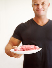 Image showing Food, diet and man with raw meat for a body builder, protein and carnivore eating plan to bulk. Cooking, health and portrait of a male person with beef or steak to cook healthy dinner, lunch or meal.