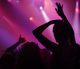 Image showing Neon, light and people dancing at concert or music festival, energy in silhouette at live show event. Dance, fun and purple lighting at party, group of excited fans in arena at rock band performance.