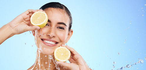 Image showing Beauty, lemon and water splash with portrait of woman in studio for natural cosmetics, nutrition and mockup. Glow, fruits and hydration with female on blue background for vitamin c, face and skincare