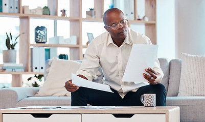 Image showing Man reading paperwork in living room home for planning, budget report and investment contract. Black male, notes and remote work in lounge of tax documents, financial savings or insurance information