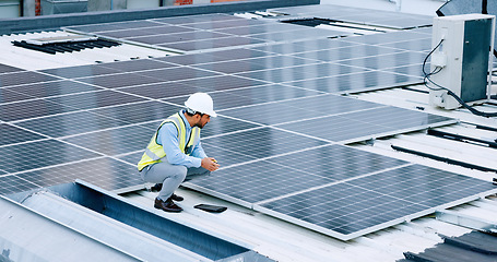 Image showing Engineer or contractor measuring solar panels on a roof of a building. Engineering technician or electrician installing alternative clean energy equipment and holding a tablet to record measurements