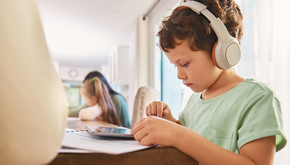 Image showing Child, headphones and tablet for education and learning at a home table with internet connection. Boy kid using technology for educational mobile app, streaming video and movies or listening to sound