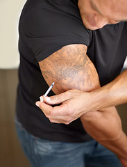 Image showing Closeup, steroids and man with needle, drugs or fitness with tattoo, medical or muscular. Zoom, male person or bodybuilder with syringe, illegal testosterone or injection with bicep growth or hormone