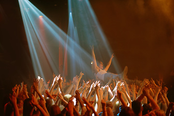 Image showing Stage dive, hands and people at music festival, neon spotlight and energy at live concert event. Dance, fun and group of excited fans in arena at rock show performance, audience carrying crowd surfer