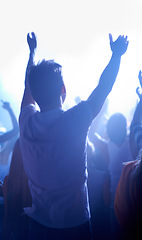 Image showing Music festival, concert and man in crowd from back, dancing in neon lights and energy at live event. Dance, fun and excited fans in arena at rock band performance or audience at techno rave party.