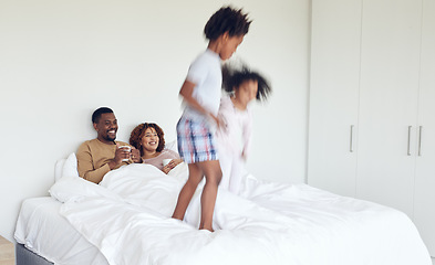 Image showing Love, parents in bed and children jumping, quality time and happiness with bonding, home and cheerful. Family, energy and siblings with mother, father and kids playing in bedroom, joyful and morning