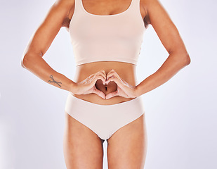 Image showing Woman, heart and hands on stomach in studio as motivation for weight loss, diet or fitness. Female on a white background with hand emoji or shape for gut health, wellness or skin care in underwear