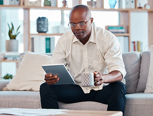 Image showing Tablet, coffee and relax with a black man on the sofa, sitting in the living room of his home or office. Business, tech and research with a male employee reading an online article while on a break