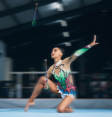 Image showing Woman, gymnast and dance sticks with balance and focus in a gym for dancing performance art. Exercise, training and sports competition of an athlete with moving for show for fitness and dancer sport