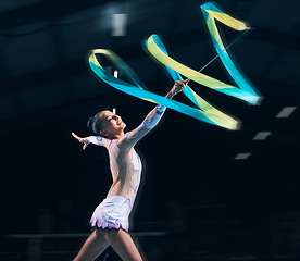 Image showing Ribbon gymnastics, woman and smile in motion blur of dancer, talent show and competition in dark arena. Happy female athlete, rhythmic movement and dancing for action, creative sports and performance