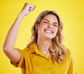 Image showing Woman, fist celebration and happy in studio for winning, goals and success for achievement by yellow background. Girl, excited and winner with bonus, profit and prize from competition by backdrop