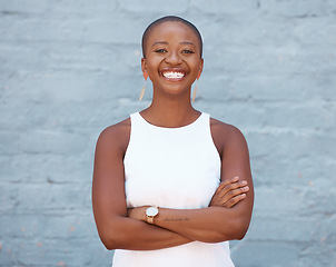 Image showing Happy, brick wall and portrait of a black woman with arms crossed, pride and smiling with confidence. Smile, confident and a young African girl standing looking proud, motivated and empowered