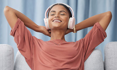 Image showing Relax, headphones and woman on a living room sofa feeling peace from music. Web radio, home and podcast of a young female with a smile from zen and stress relief audio on a lounge couch in a house