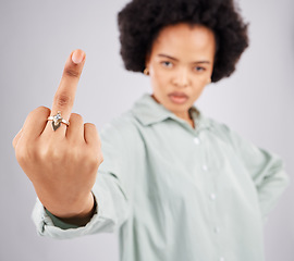 Image showing Portrait of black woman, opinion and middle finger in studio, angry expression in conflict on isolated on white background. Fingers, rude hand gesture and offended, frustrated person in anger or hate