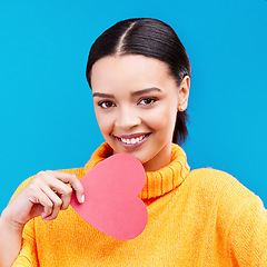 Image showing Paper heart, portrait and happy woman on blue background, love icon and romantic flirting sign. Female model, emoji shape and smile of care, support and thank you for kindness, valentines day or date