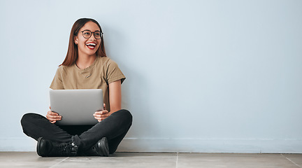 Image showing Thinking, floor and woman laughing with laptop in home by wall background with mockup. Happiness, computer and funny person sitting on ground with pc for online meme, social media and comedy idea.