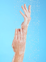 Image showing Woman, hands and water drops, hygiene and handwashing, skincare and moisture on blue background. Natural, sustainability and wellness with eco friendly dermatology, shower and cleaning for health