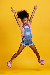 Image showing Happy, jump and child hands raised jumping in happiness, joy and smile while isolated in a studio yellow background. Energy, celebrate and kid in the air due to winning, celebrating and success