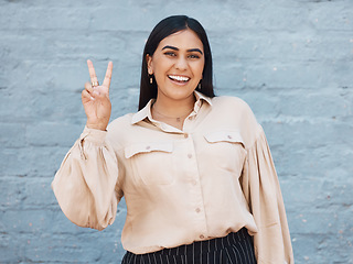 Image showing Happy woman, portrait smile and peace sign in business against a gray wall background. Excited and friendly female face smiling showing peaceful hand emoji, sign or gesture with positive attitude