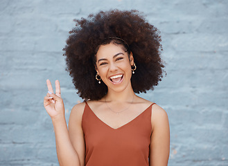 Image showing Happy woman, portrait smile and afro with peace sign against a gray wall background. Excited or friendly female face smiling showing peaceful hand emoji or gesture with fun positive attitude