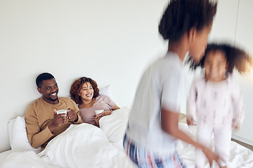 Image showing Mother, father and children jump on bed in morning for playing together, fun and quality time at home. Love, black family and happy mom and dad with motion blur kids with energy, jumping and excited