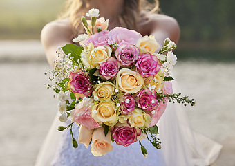 Image showing Closeup, bride and flower bouquet outdoor for celebration of commitment, ceremony and marriage. Woman, wedding and holding roses, spring flowers and floral blossom to celebrate love at elegant event