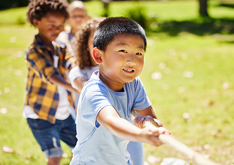 Image showing Fun, games and children playing tug of war together outdoor in a park or playground during summer. Friends, diversity and kids pulling a rope while having fun or bonding in a garden on a sunny day
