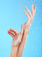 Image showing Closeup woman, water drops and washing hands on blue background, studio backdrop or sustainability skincare. Female model, hand and liquid for showering, cleaning and beauty of dermatology wellness