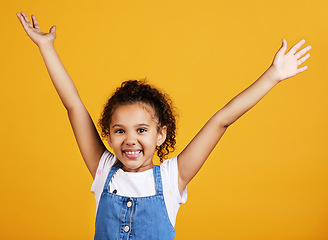 Image showing Studio, portrait and excited child with hands up and smile on face on yellow background. Young girl kid with happiness, carefree and positive attitude or happy celebration or surprise announcement