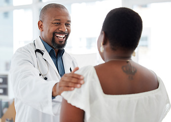 Image showing Doctor, black man and touch shoulder of patient for support, comfort and reassure in hospital. Healthcare, consultation and happy medical professional talking, good news or laughing with mature woman