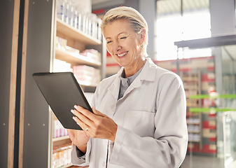 Image showing Doctor, woman and tablet in pharmacy for research, healthcare or checking stock and inventory at supermarket. Happy senior female medical pharmacist smiling on touchscreen for results at retail store