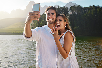 Image showing Couple, nature selfie and engagement by lake for celebration, happiness and excited for future. Man, woman and photography for social media, profile picture and romance with love, proposal and goals