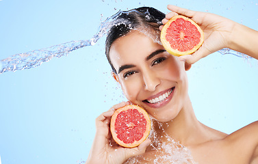 Image showing Grapefruit, water or happy girl portrait with beauty in studio on blue background for healthcare or natural diet. Smile, wellness or healthy model face with fruits or vitamin c for skincare or detox