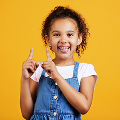 Image showing Portrait, pointing up and girl with smile, branding development and happiness against a studio background. Face, female child and young person gesture for space, direction and showing with choice