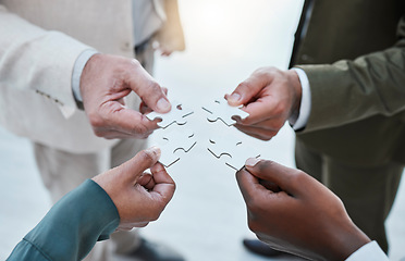 Image showing Hands, puzzle or collaboration with a business team closeup in an office for planning from above. Teamwork, strategy and jigsaw pieces with a group of employee people or colleagues working in synergy