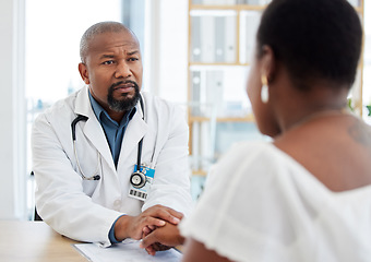 Image showing Serious doctor, patient and holding hands in consultation for bad news, cancer diagnosis or comfort. Healthcare, black man and medical professional with woman for help, support and empathy in clinic.