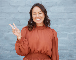 Image showing Happy woman, portrait smile and beauty with peace sign against a gray wall background. Excited and friendly female face smiling showing peaceful hand emoji, symbol or gesture with positive attitude