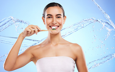 Image showing Portrait, water splash or happy woman brushing teeth with product for healthy oral or dental hygiene in studio. Face, smile beauty or girl model cleaning mouth with a natural bamboo wooden toothbrush