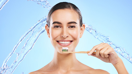 Image showing Portrait, water splash or happy girl brushing teeth with product for healthy oral or dental hygiene in studio. Face, smile beauty or woman model cleaning mouth with a natural bamboo wooden toothbrush