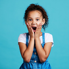 Image showing Portrait, surprise and girl with wow, facial expression and happiness against a blue studio background. Face, female child and young person with shock, wow and gasp with emoji gesture and good news