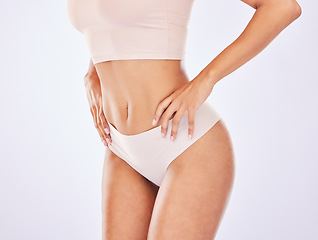 Image showing Woman, body and stomach for healthy lifestyle in studio as motivation for weight loss, diet or fitness. Female on a white background with hand on waist for health, wellness or skin care in underwear