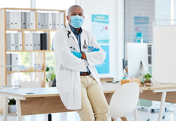 Image showing Covid, portrait and a doctor black man in his office, standing arms crossed for healthcare or insurance. Medical, mask and trust with a male medicine professional at work in a wellness clinic