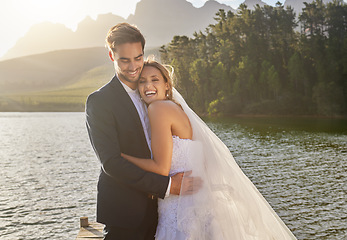 Image showing Happy, hug and lake with a couple after a wedding for a ceremony, celebration and marriage. Smile, affection and funny with a man and woman laughing after a romantic relationship commitment in nature