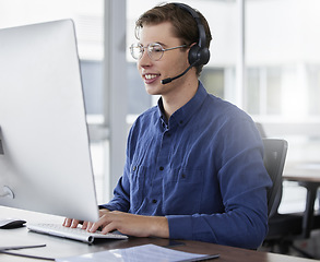 Image showing Man, call center and typing on computer, smile in office and working on customer service in workplace. Telemarketing, desktop and happiness of person, male sales agent or consultant consulting online