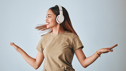 Image showing Woman, music headphones and dancing in studio while happy, excited and positive. Female model on white background to dance with hands, fun and smile with energy and listening to audio or radio