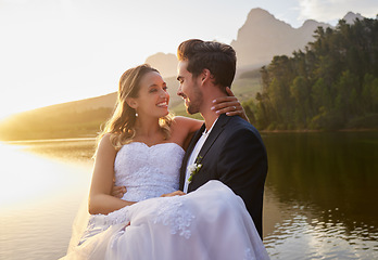 Image showing Lake, wedding and man carrying his bride while having an intimate moment together in nature. Happiness, love and young couple with affection on their romantic outdoor marriage day ceremony by forest.