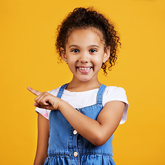 Image showing Portrait, smile and girl pointing to space, direction and choice against a studio background. Face, female child and young person with gesture for decision, branding development and product placement