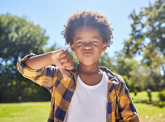 Image showing Thumbs down, portrait or angry child in park unhappy, upset or frustrated in nature. Young African boy kid being negative by disagreeing with wrong sign, poor review or no body language