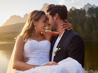 Image showing Intimate, love and couple at their wedding by the lake with affection moment together in nature. Happiness, smile and young groom and bride on their romantic outdoor marriage day ceremony by forest.